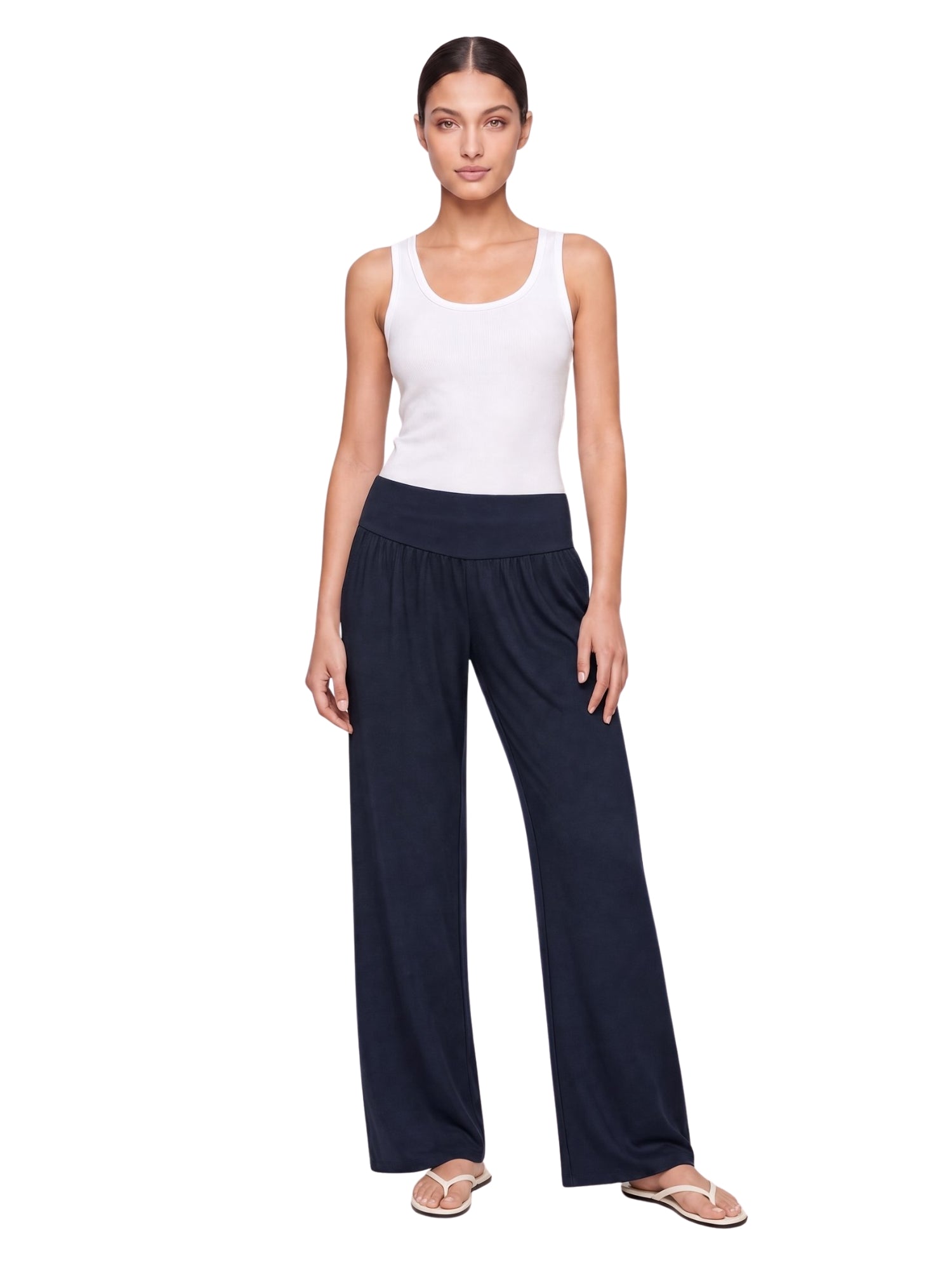 Woman wearing navy wide-leg lounge pants with white tank top, ideal for travel and comfort at home.