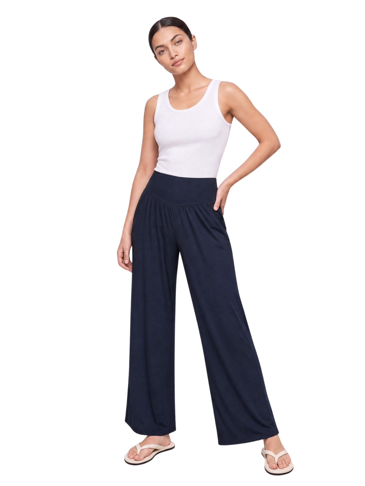 Woman modeling navy wide-leg lounge pants with elastic waist, paired with white tank top and flip flops